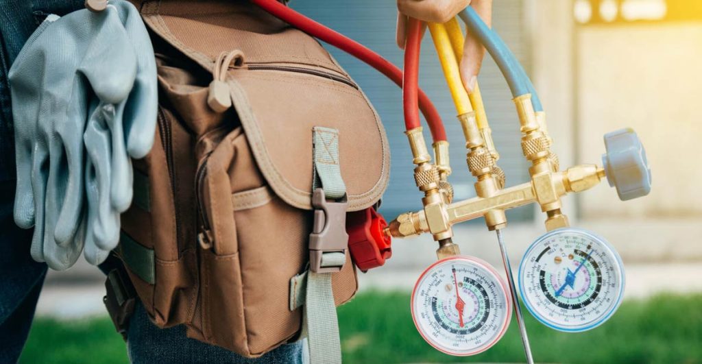HVAC technician with gauges and tools