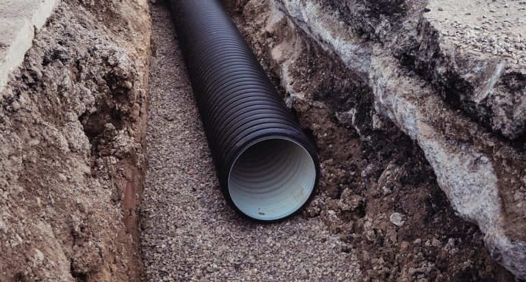 Large corrugated drainage pipe installed in a trench during construction.