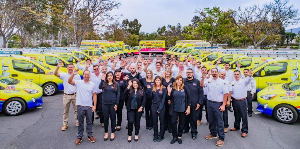 Connex Valley team proudly stands with their fleet of yellow service vehicles. Family owned and operated since 1979.