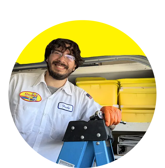 Conejo Services garage door service technician smiling on a ladder in a garage