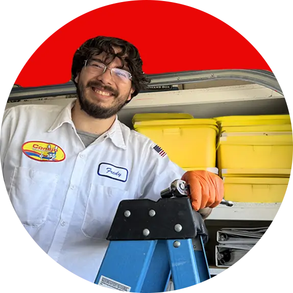 Conejo Services garage door service technician smiling on a ladder in a garage